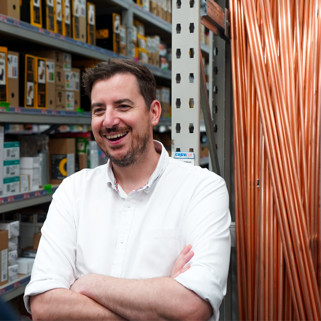 Mike Reader MP standing on a factory floor smiling